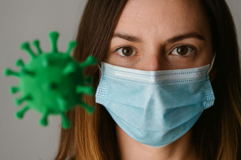 Woman wearing a mask looks at a green virus model, illustrating the impact of COVID-19 on the hierarchy of needs.
