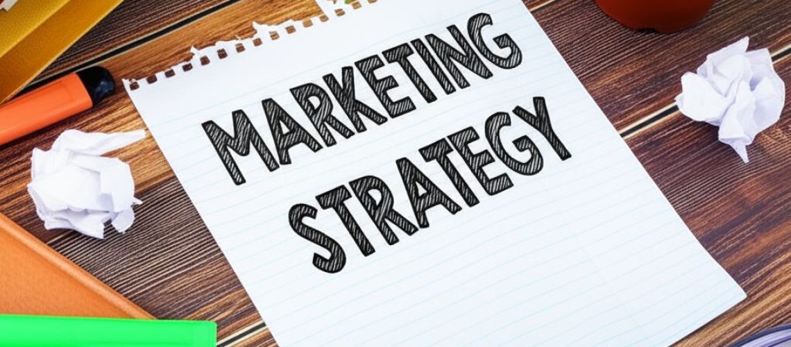 Notepad with "Marketing Strategy" surrounded by office supplies, illustrating marketing strategies every business can afford.
